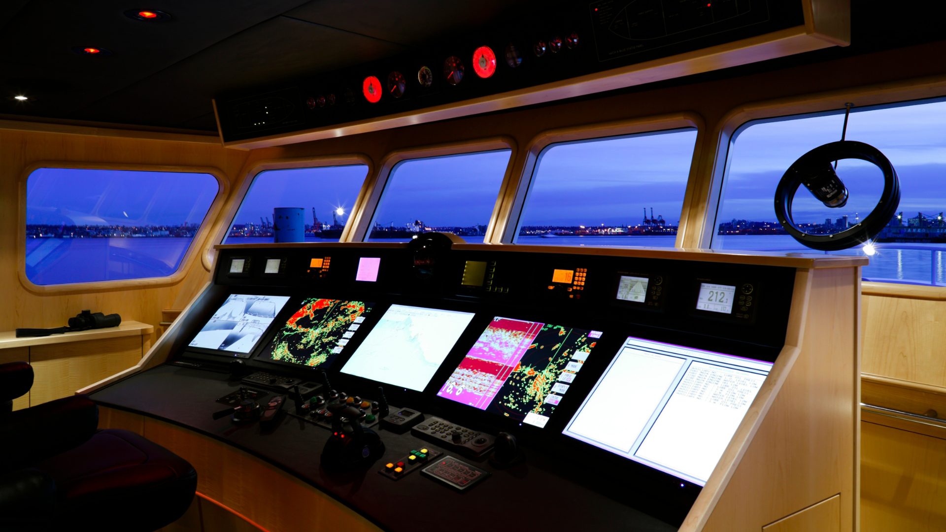 Ship bridge at dusk, consoles lit, harbour beyond